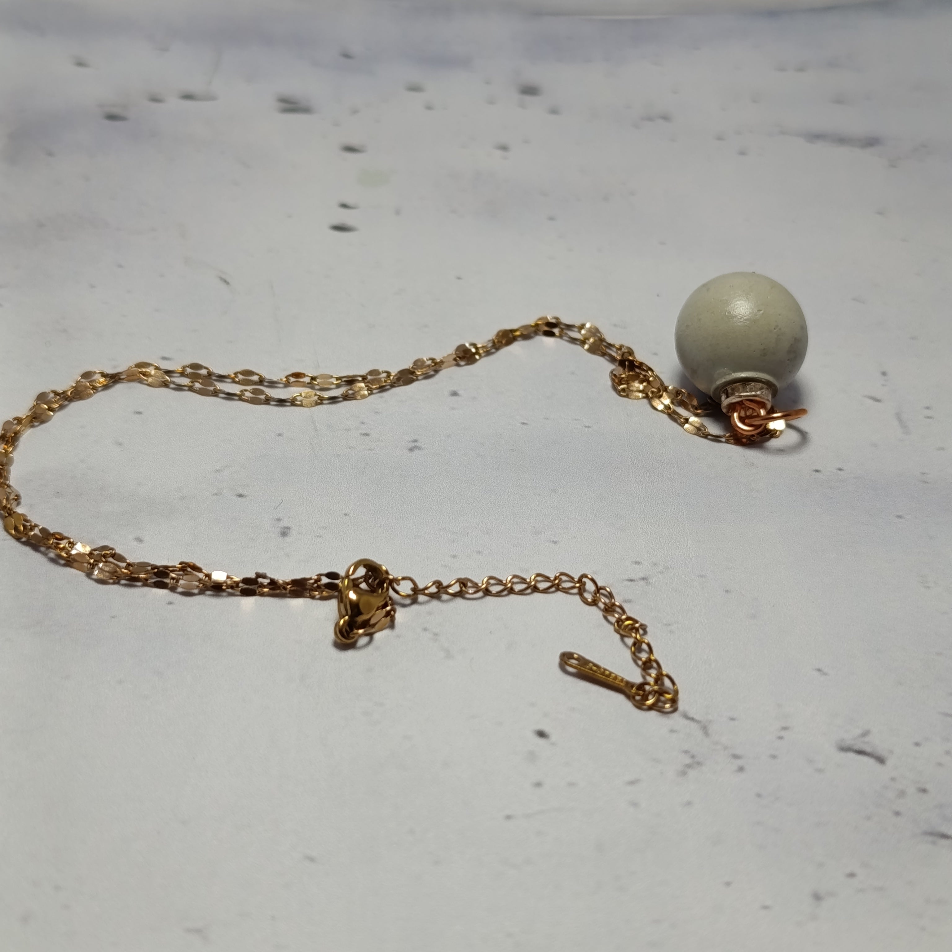 Collier Nébula – Béton Brut Gris Clair & Inox Doré Une Lueur de Bonheur