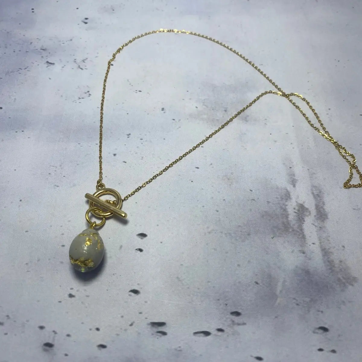 Collier Ovale Doré – Béton & Or Une Lueur de Bonheur
