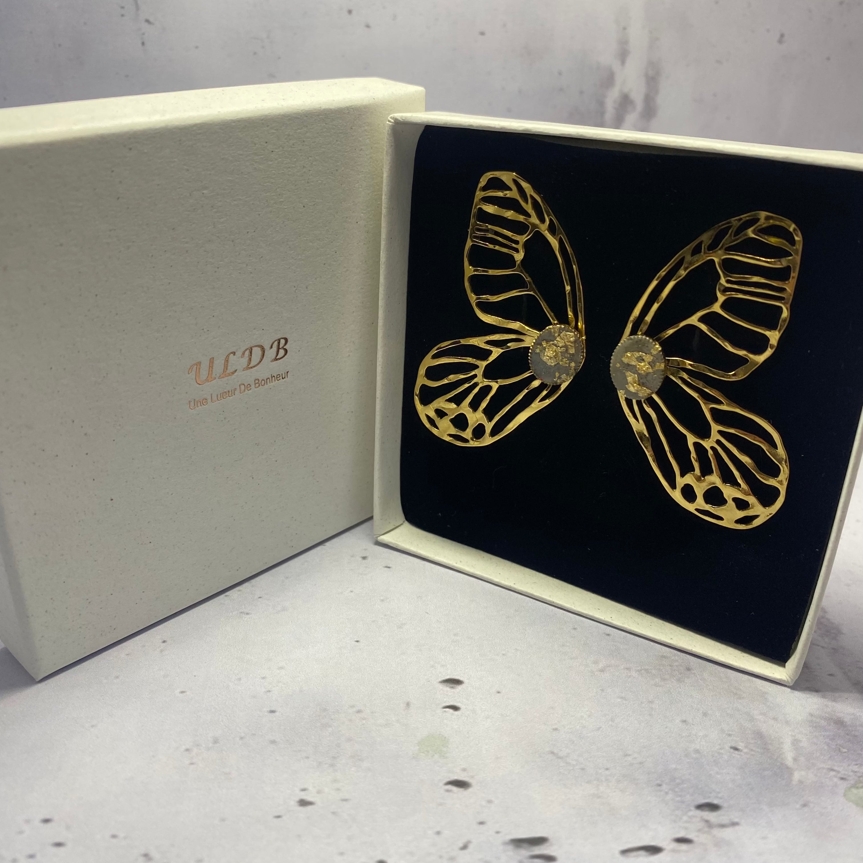 Boucles d’oreilles Papilia – Acier Doré & Béton Une Lueur de Bonheur